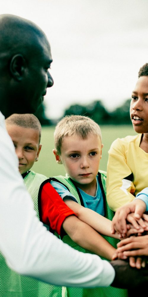 Junior,Football,Team,Stacking,Hands,Before,A,Match Volunteer training soccer team